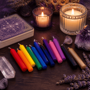 Short colorful chime candles on a wooden altar with candles and crystals