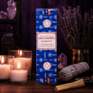 Nag Champa incense box on a wooden table with candles, sage, and palo santo